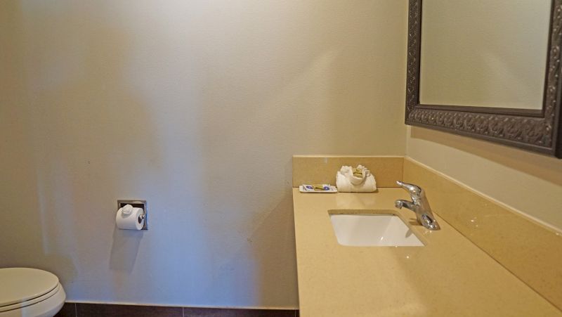 A bathroom with a sink, toilet, and mirror