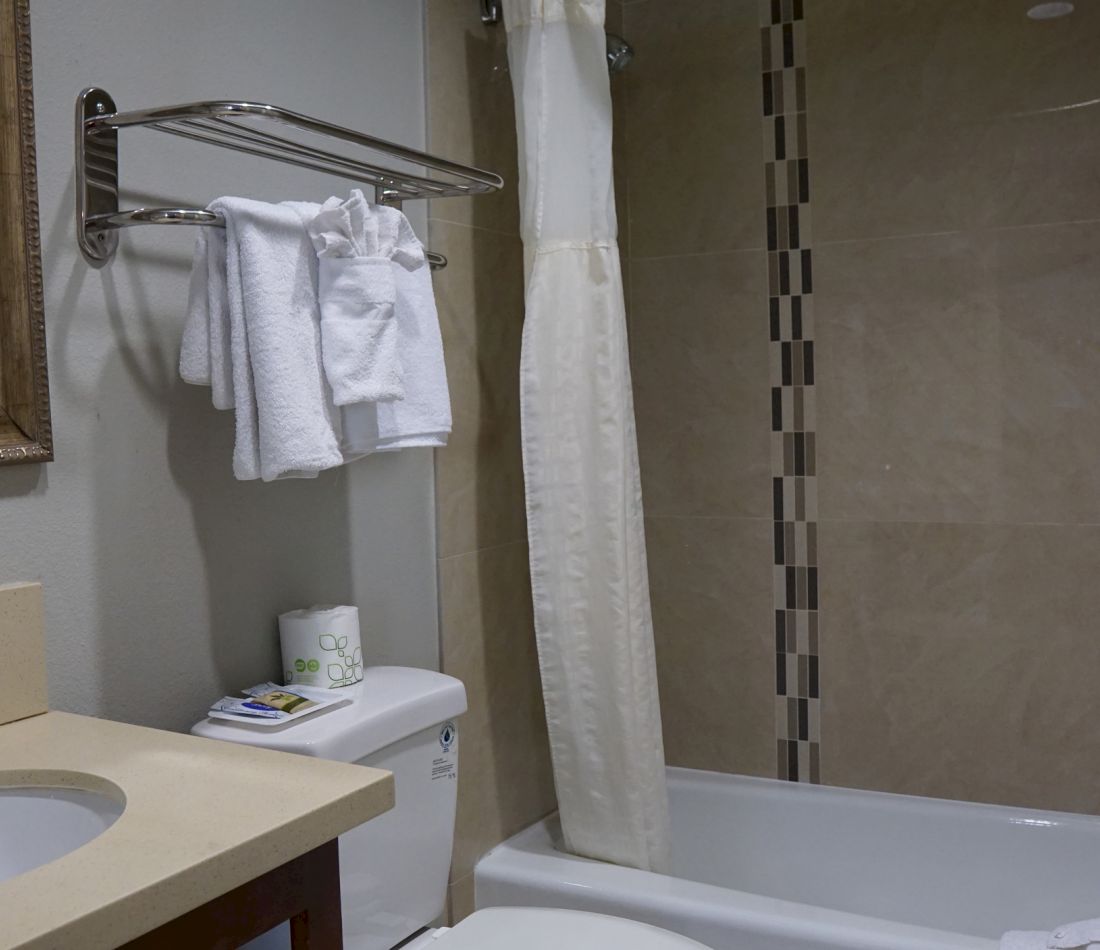 A standard hotel bathroom with a tub, toilet, and sink
