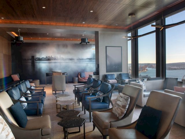 A lounge with a seating area, large windows, and a city view.