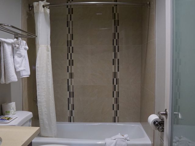 A clean bathroom with a bathtub, shower, and tiled walls.